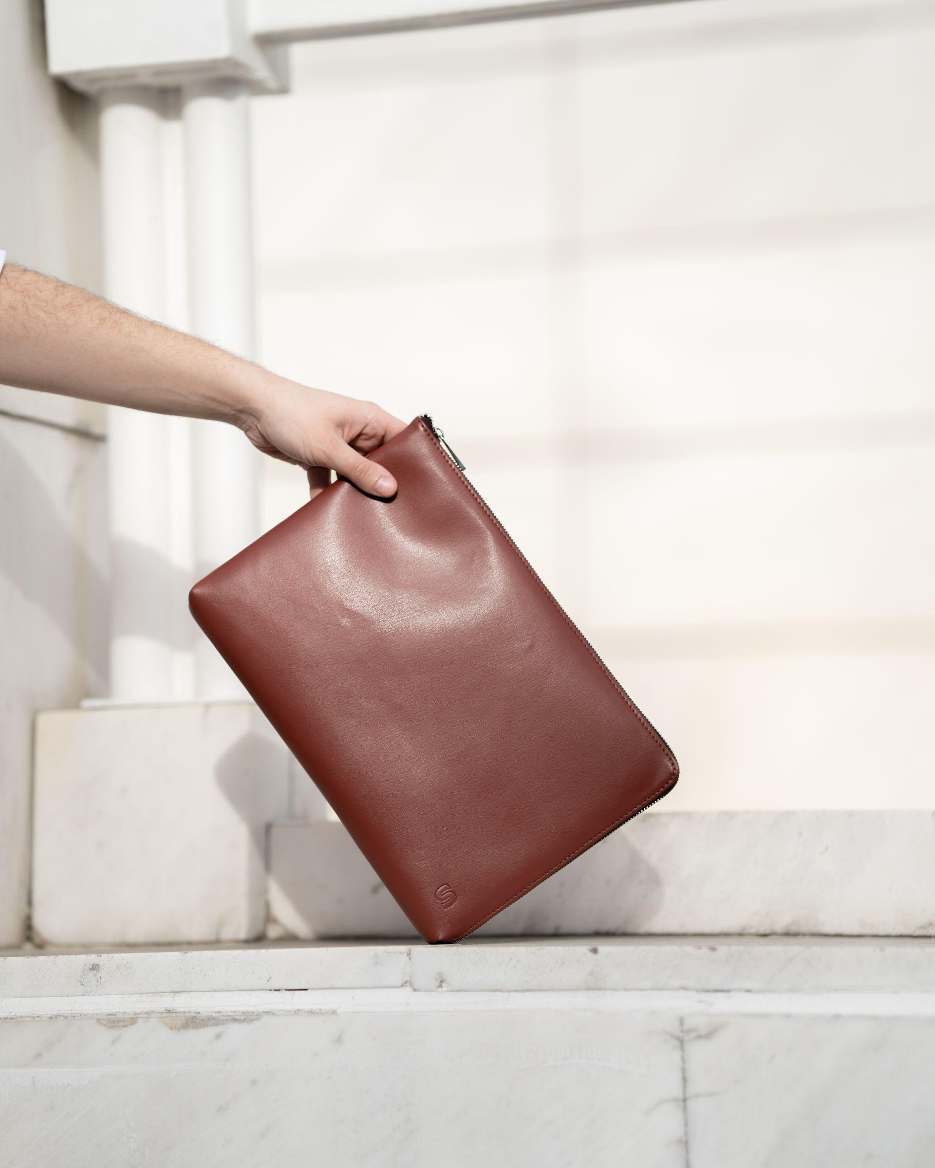 Brown leather laptop case being held 