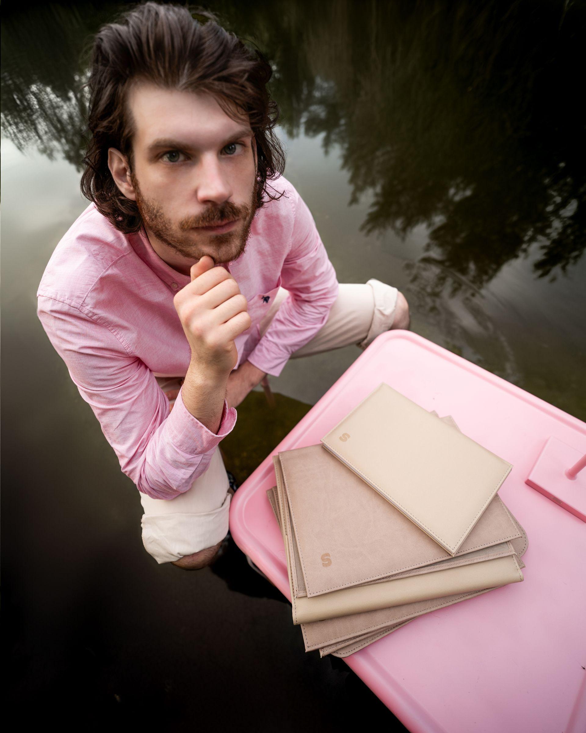 Model posing in lake with book binding plant based leather